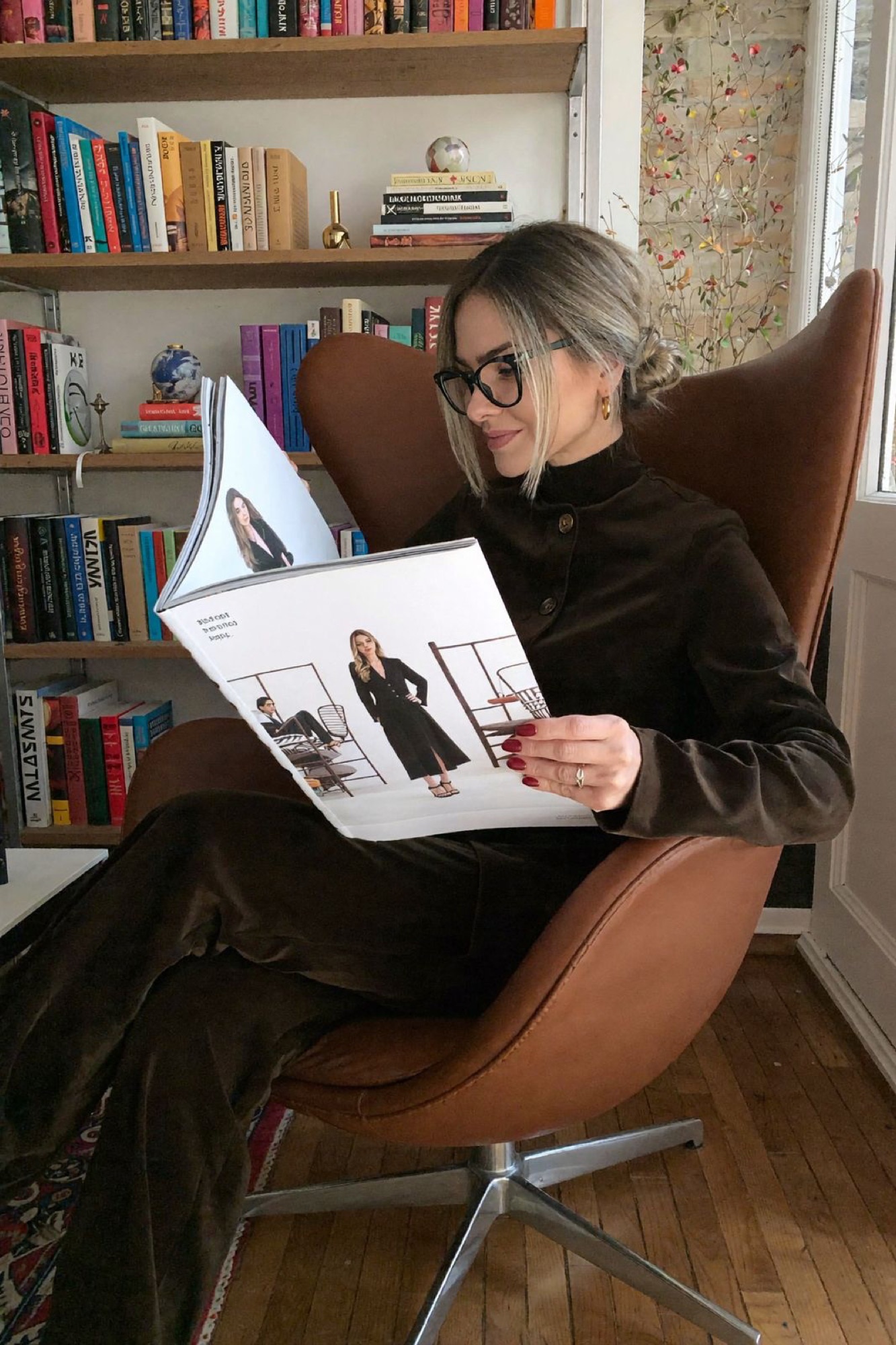 Betina Weber reading in a leather chair, a quiet moment of reflection