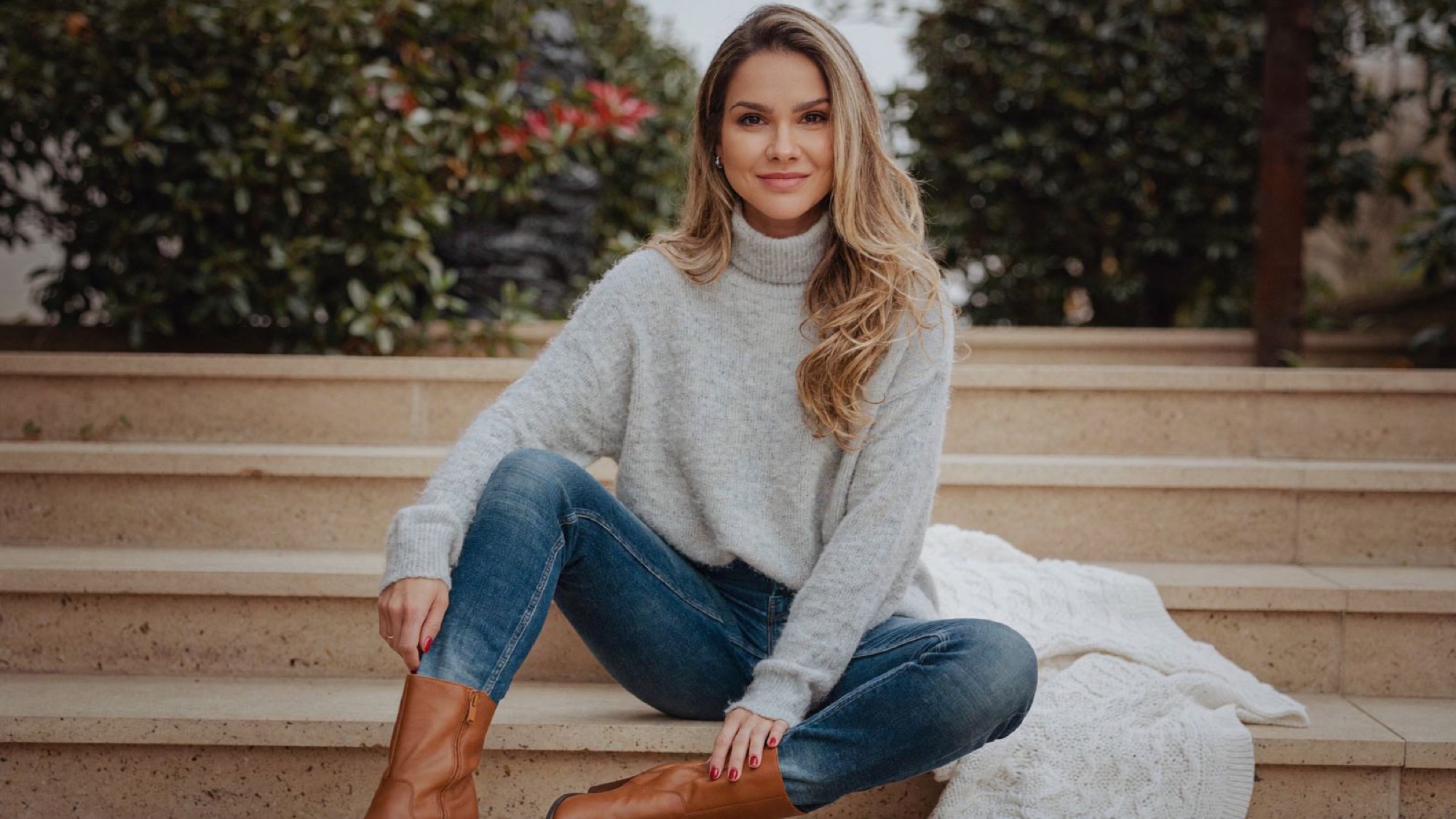 Betina Weber seated on garden steps in relaxed attire